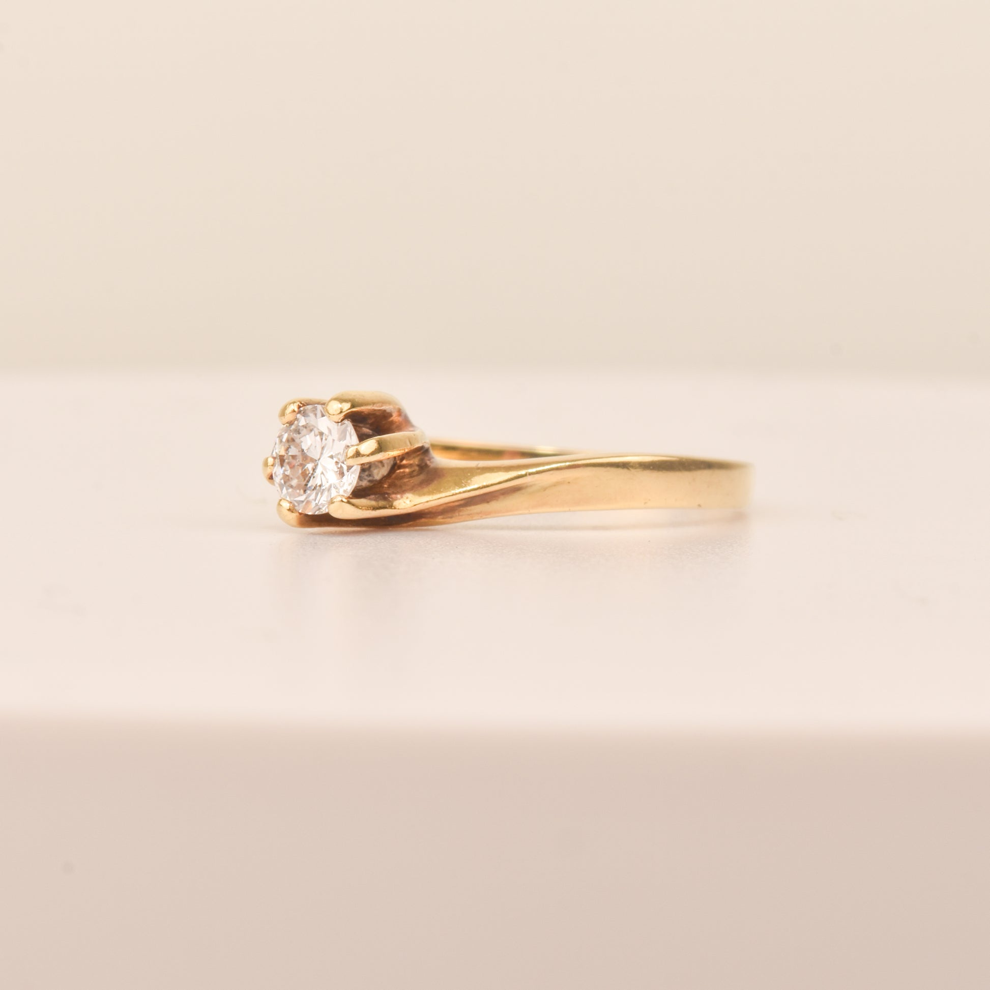 18K yellow gold solitaire engagement ring with a 6-prong spiral setting and diamond, size 7.5 US, on a neutral background.