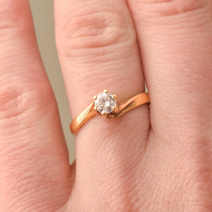 18K yellow gold diamond solitaire engagement ring with a 6-prong spiral setting on a size 7.5 US finger.