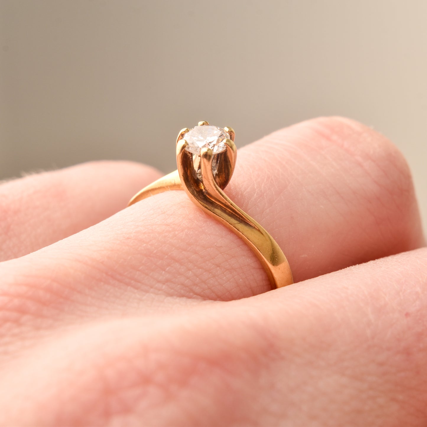 18K yellow gold diamond solitaire engagement ring with 6-prong spiral setting, showcased on a finger, size 7.5 US.