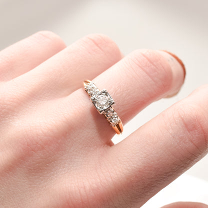 14K two-tone gold diamond engagement ring with a .25 carat brilliant center stone, size 9 US, on a finger against a soft background.