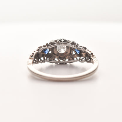 Art Deco 18K white gold diamond and synthetic sapphire engagement ring with filigree design, size 6.25 US, on a white background.