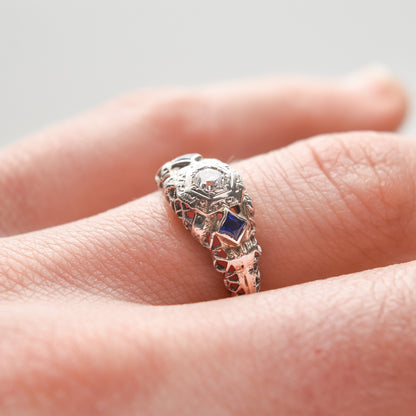 Art Deco 18K white gold diamond sapphire filigree engagement ring with natural diamonds and synthetic sapphires, size 6.25 US, showcased on a finger.