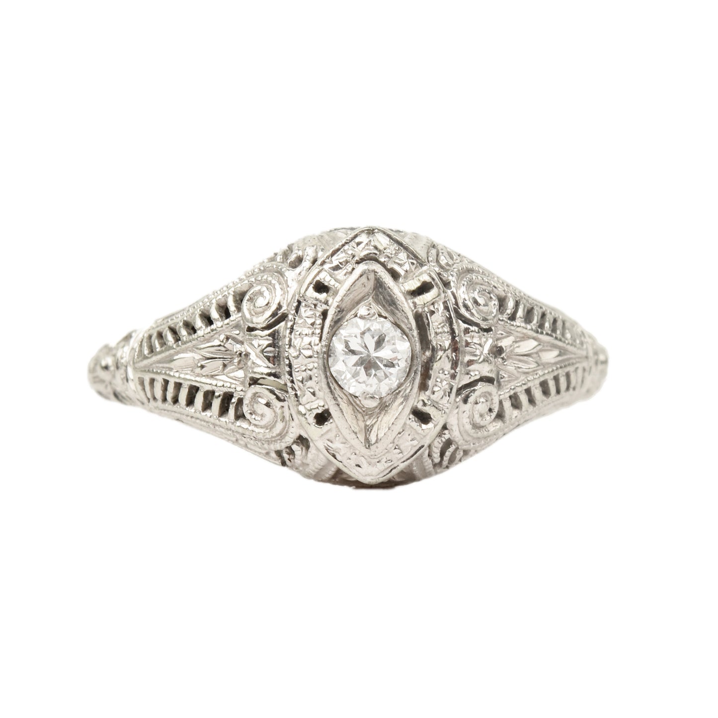 Art Deco 18K white gold filigree diamond solitaire ring featuring a 0.08 carat brilliant-cut diamond, size 6.25 US, with intricate metalwork details on a white background