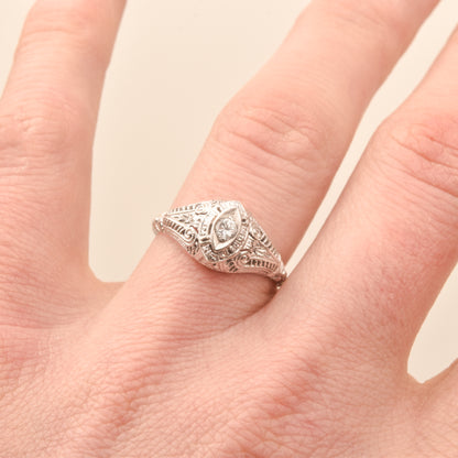 Art Deco 18K filigree diamond solitaire ring with .08 CT brilliant diamond, size 6.25 US, displayed on a finger.