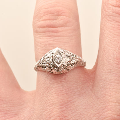 Art Deco 18K filigree diamond solitaire ring with 0.08 CT brilliant diamond, size 6.25 US, on a person's finger