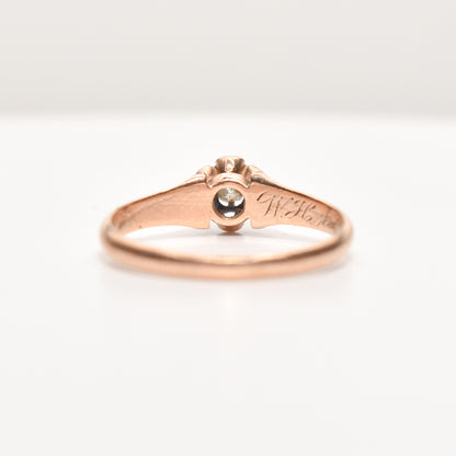 Antique 10K rose gold engagement ring with a .12 carat old mine cut diamond, estate jewelry, size 7.75 US, on a white background.