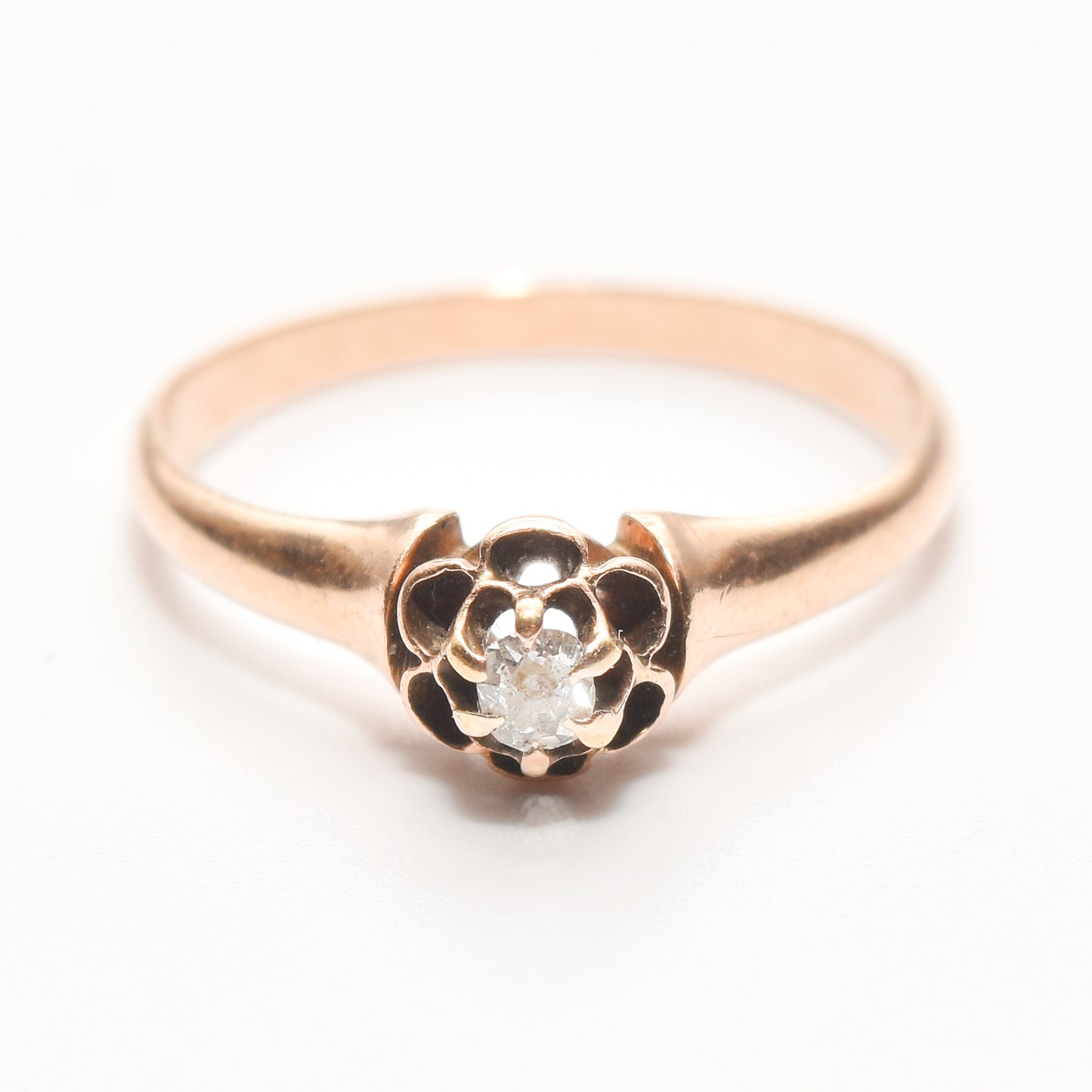 Antique 10K rose gold diamond engagement ring featuring a .12 carat old mine cut diamond, estate jewelry, size 7.75 US, on a white background.