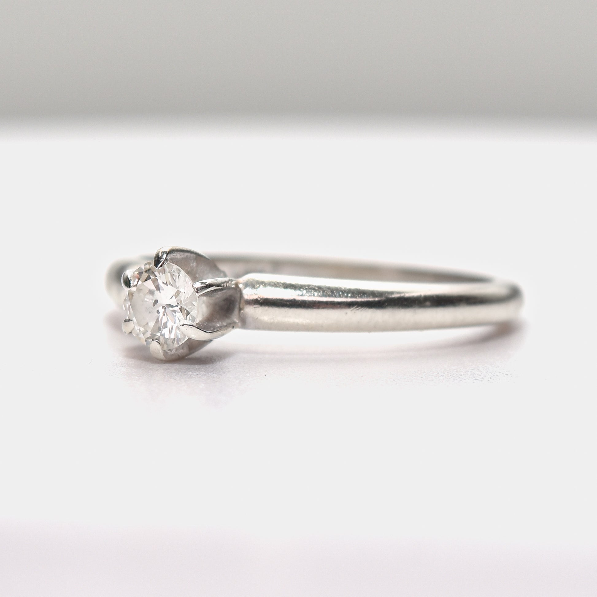 Minimalist 14K white gold engagement ring featuring a .25 carat brilliant solitaire diamond, size 6.25 US, on a clean background.