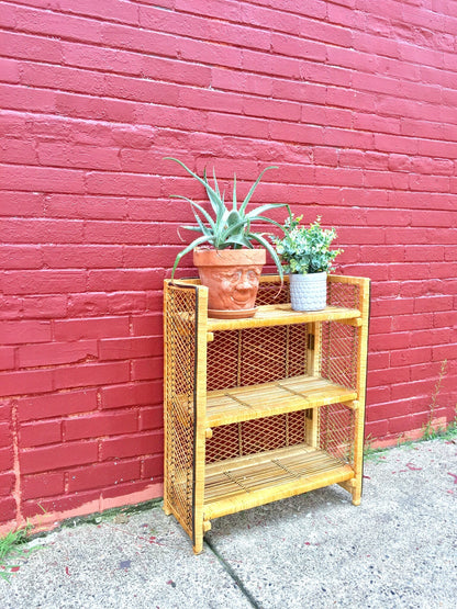 Vintage wicker shelf with plants against red brick wall, bohemian home decor