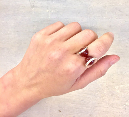 Vintage sterling silver ring with carnelian stone, handcrafted in Taxco, Mexico, shown on a hand against a light textured background.