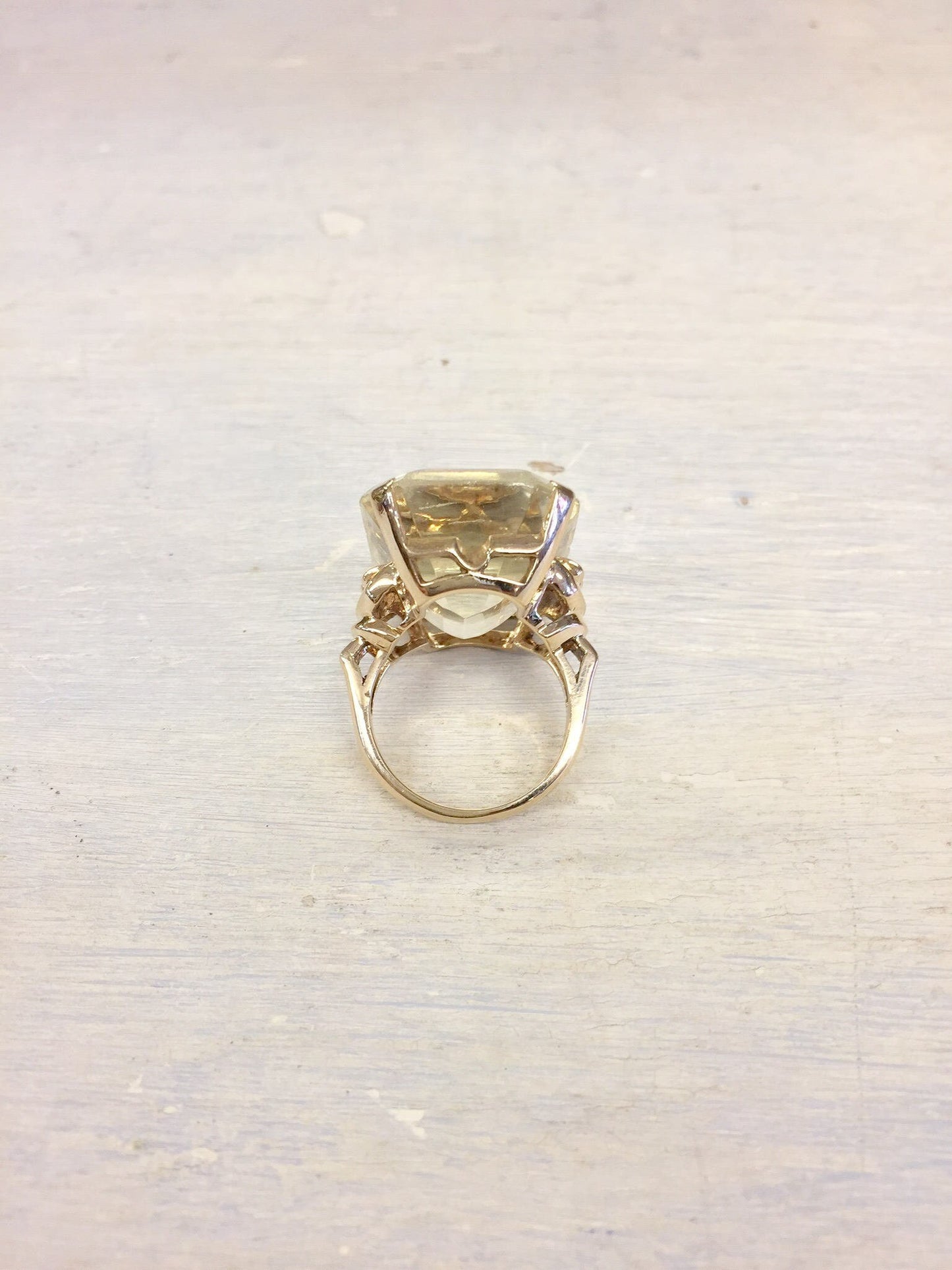 14 karat yellow gold vintage cocktail ring with large faceted citrine gemstone centerpiece surrounded by textured gold prongs, displayed on plain white background