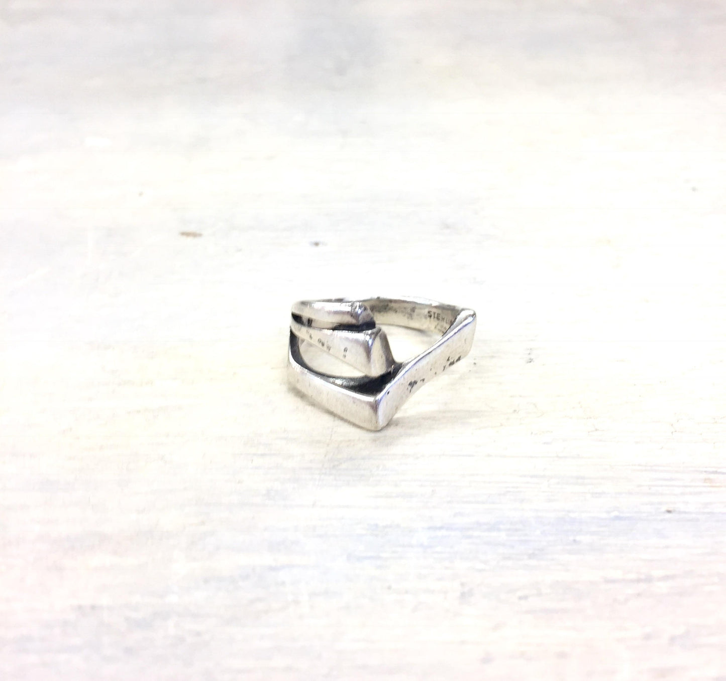 Vintage sterling silver geometric band ring on light background