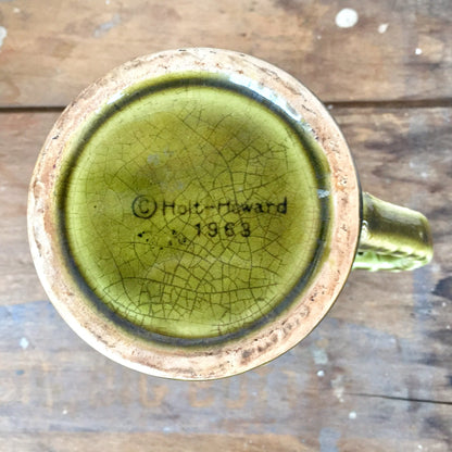 Vintage Holt-Howard 1968 ceramic mug with green crackle glaze finish on weathered wooden surface, mid-century modern drinkware gift idea.