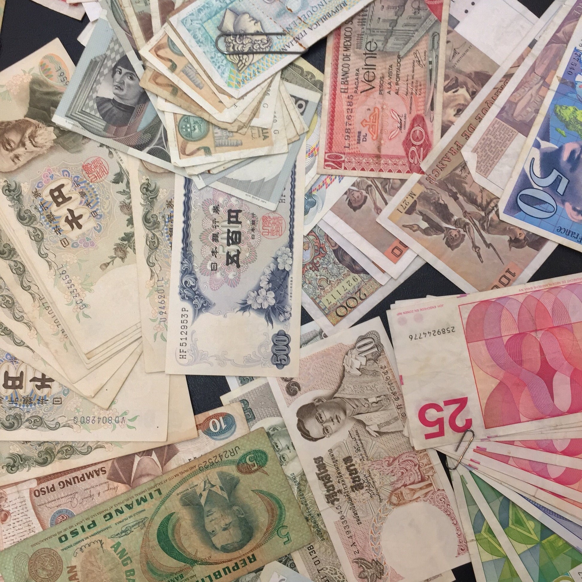 Pile of vintage foreign currency banknotes from various countries for crafts, scrapbooking or collecting