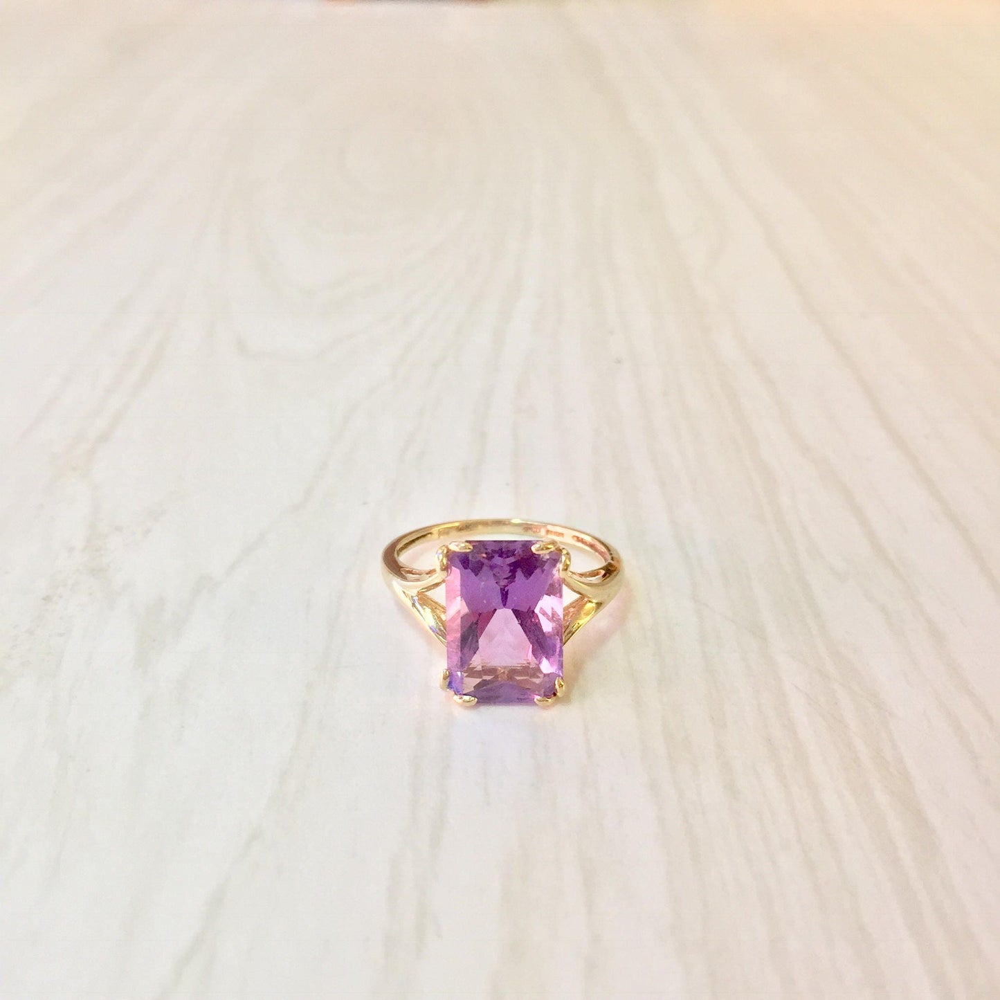 14K gold ring featuring an emerald cut amethyst gemstone, a stunning statement piece or engagement ring showcasing precious stones.