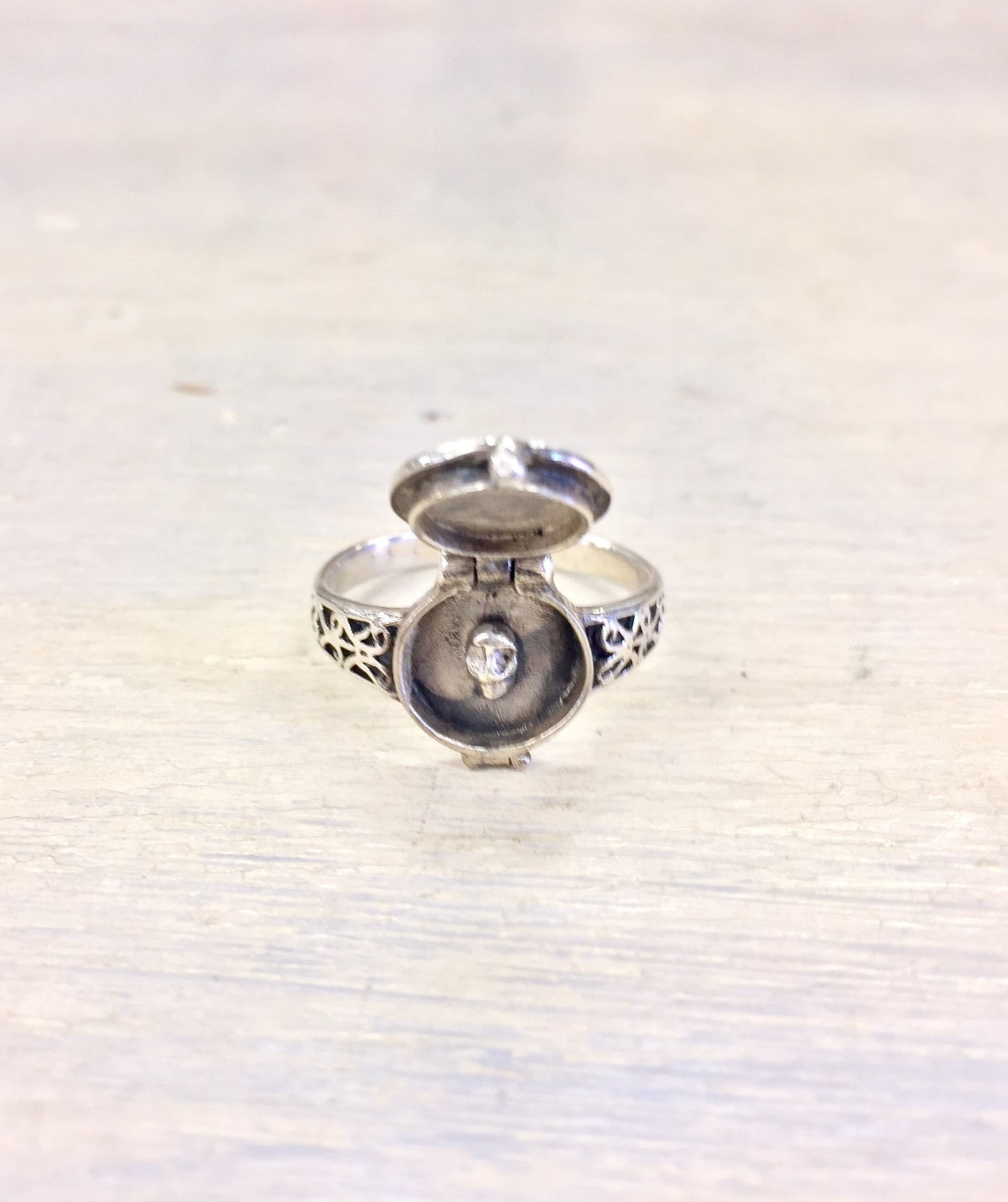 Vintage sterling silver poison ring with ornate gothic design, featuring a hinged lid concealing a hidden compartment.