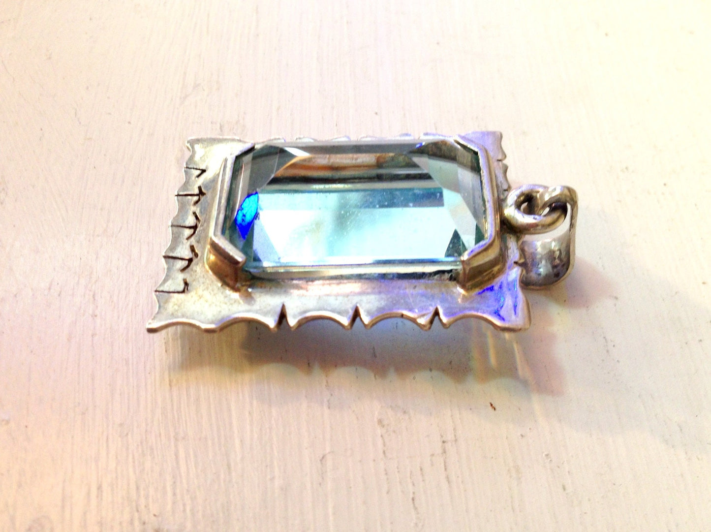 Vintage sterling silver aquamarine pendant featuring an emerald-cut aquamarine gemstone set in a decorative silver setting, photographed on a white background.