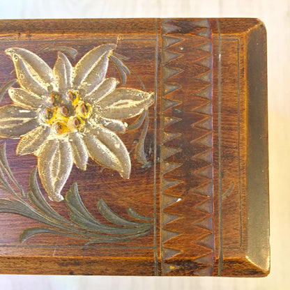 Intricate hand-carved wooden box from Zakopane, Poland featuring an ornate floral design with a three-dimensional edelweiss flower on the lid, made with traditional Polish wood carving techniques and a warm, rich wood finish.