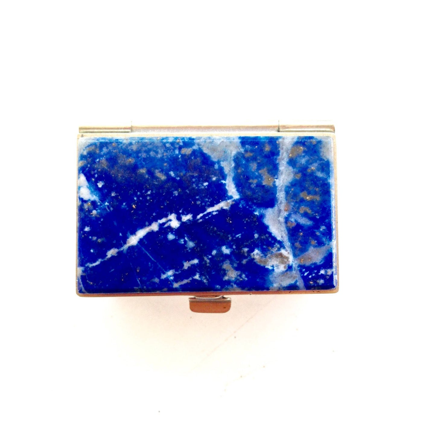 Blue lapis lazuli gemstone in a vintage gold-lined rectangular keepsake box, showing deep blue color with white calcite veining typical of lapis from Chile