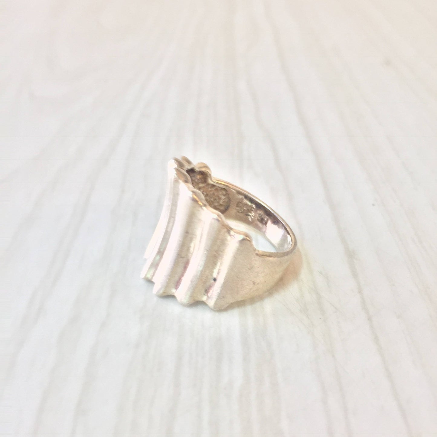 Sterling silver concave ring with textured, minimalist design suitable as a unisex statement jewelry piece or gift