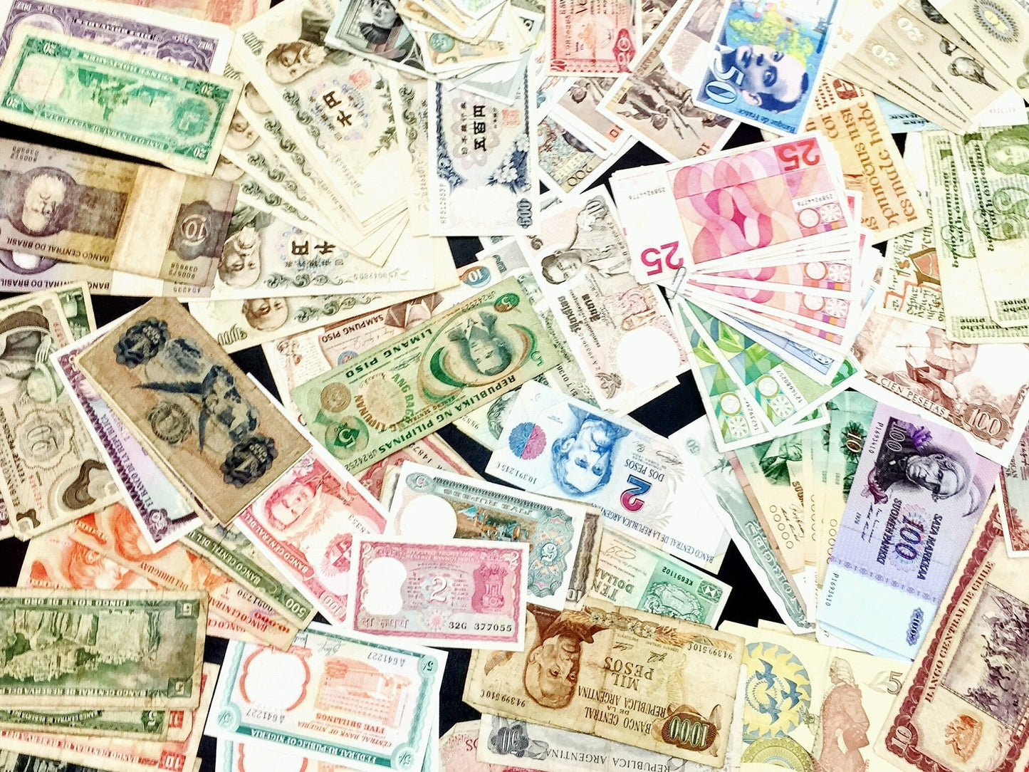 Alt text: Collection of vintage foreign paper currency and banknotes from various countries, scattered in a collage for scrapbooking or craft projects