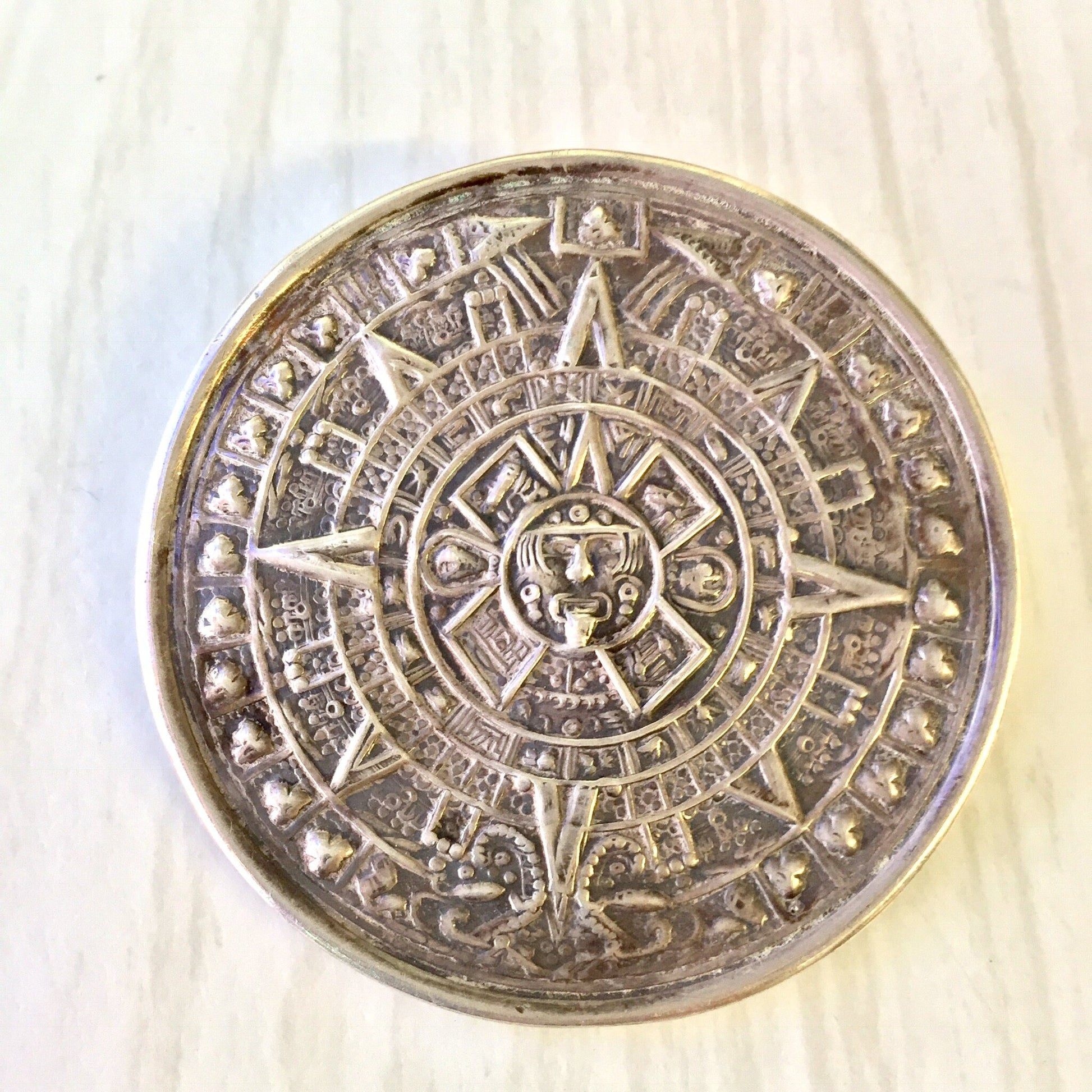 Vintage sterling silver Aztec sun calendar pendant brooch with intricate engraved details, designed as a sundial necklace. Perfect holiday gift idea from a collection of unique vintage jewelry.