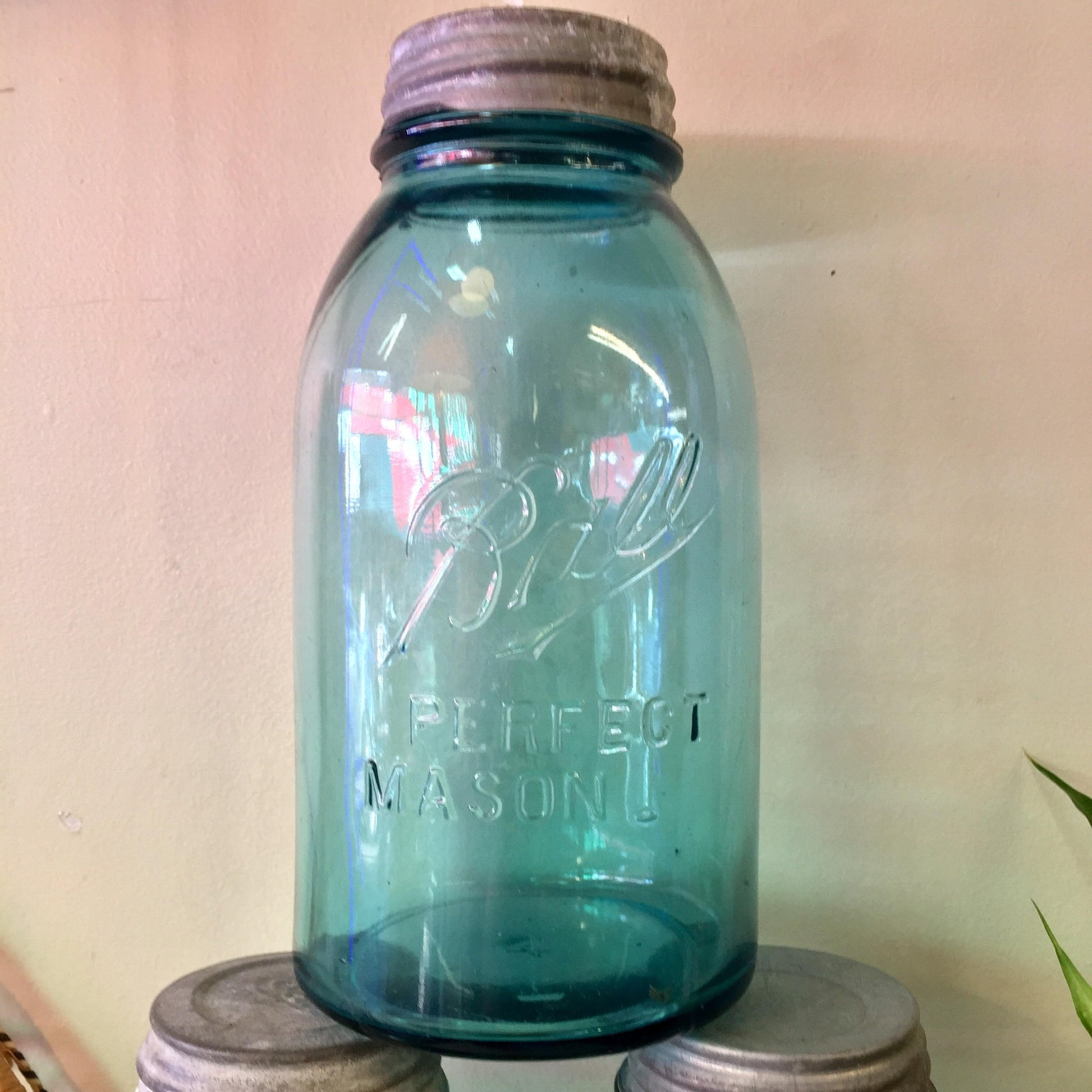 Vintage blue glass Ball Perfect Mason jar with zinc lid, hand-blown antique canning jar for rustic farmhouse decor.