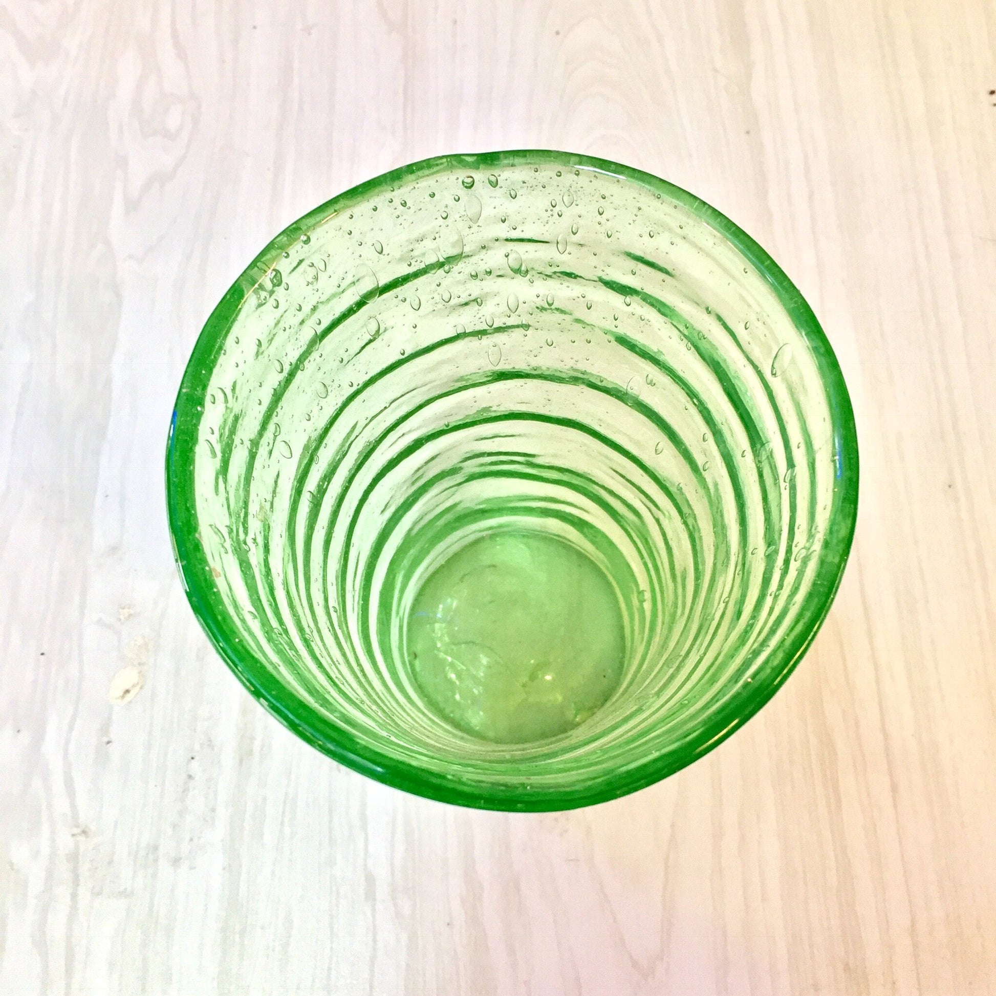 Vintage green vaseline glass cup with rippled texture and pontil mark, collectible hand-blown depression era glassware