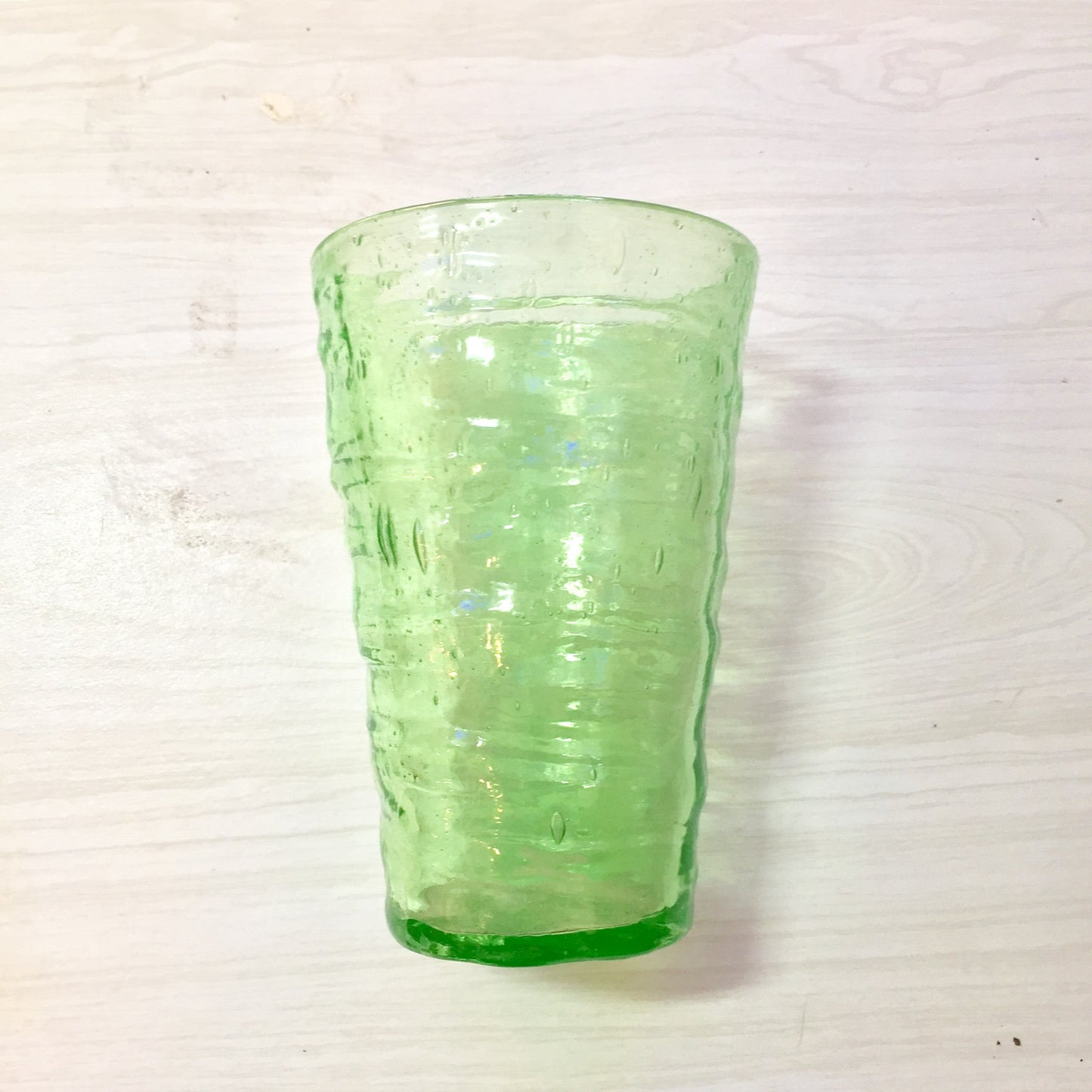 Vintage hand-blown vaseline glass cup with rippled texture and pontil mark, collectible depression glass piece in vibrant green color