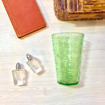 Vintage vaseline glass large cup with rippled texture, hand-blown depression glass with pontil mark, displayed alongside wicker baskets and books.