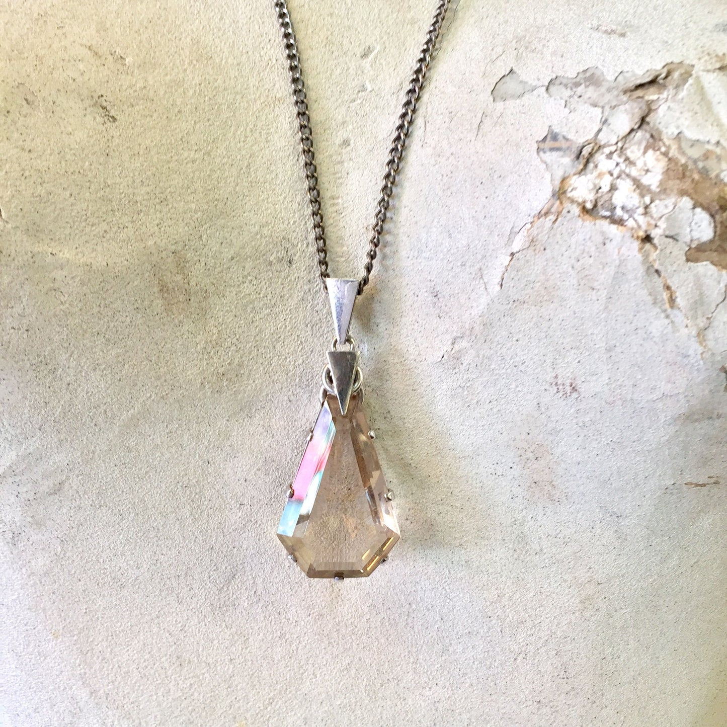 Smoky quartz pendant necklace with long chain on textured background