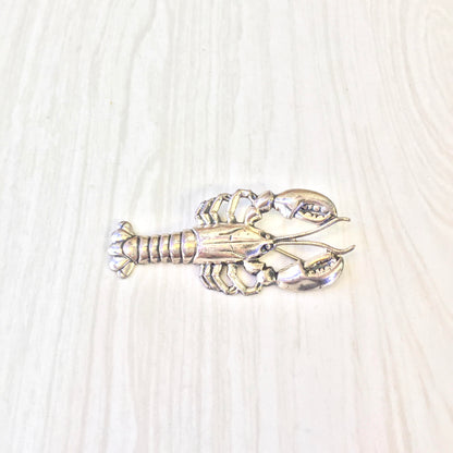 Vintage sterling silver lobster brooch pin on light wood background, detailed craftsmanship of crustacean shape, perfect holiday gift idea or unique addition to vintage jewelry collection