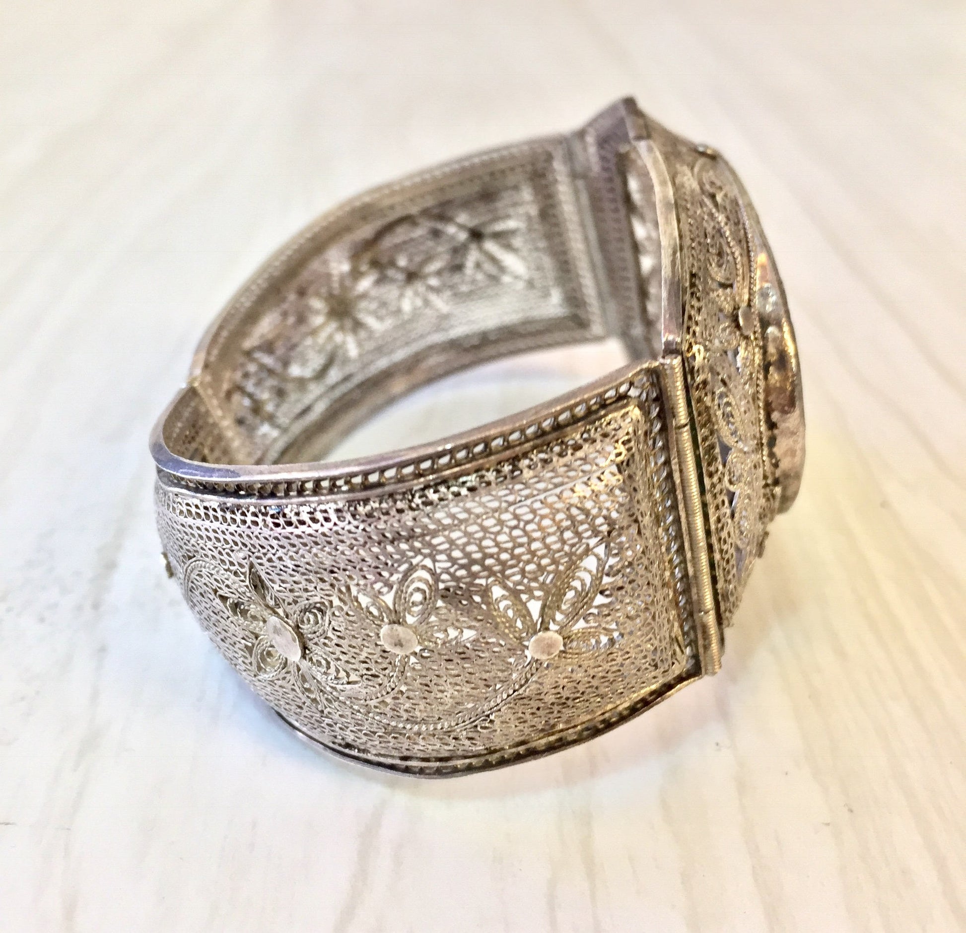 Antique sterling silver hinged filigree bracelet with intricate carved horn design, showcasing traditional Asian jewelry craftsmanship and scrimshaw technique.