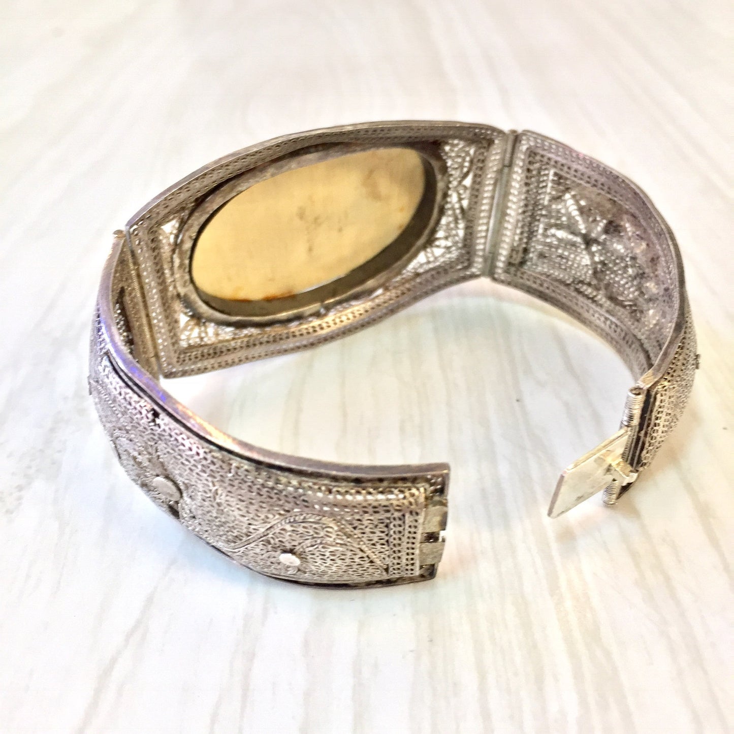 Antique sterling silver hinged filigree bracelet with intricately carved Chinese horn or scrimshaw inlay, showcasing exquisite Asian jewelry craftsmanship.