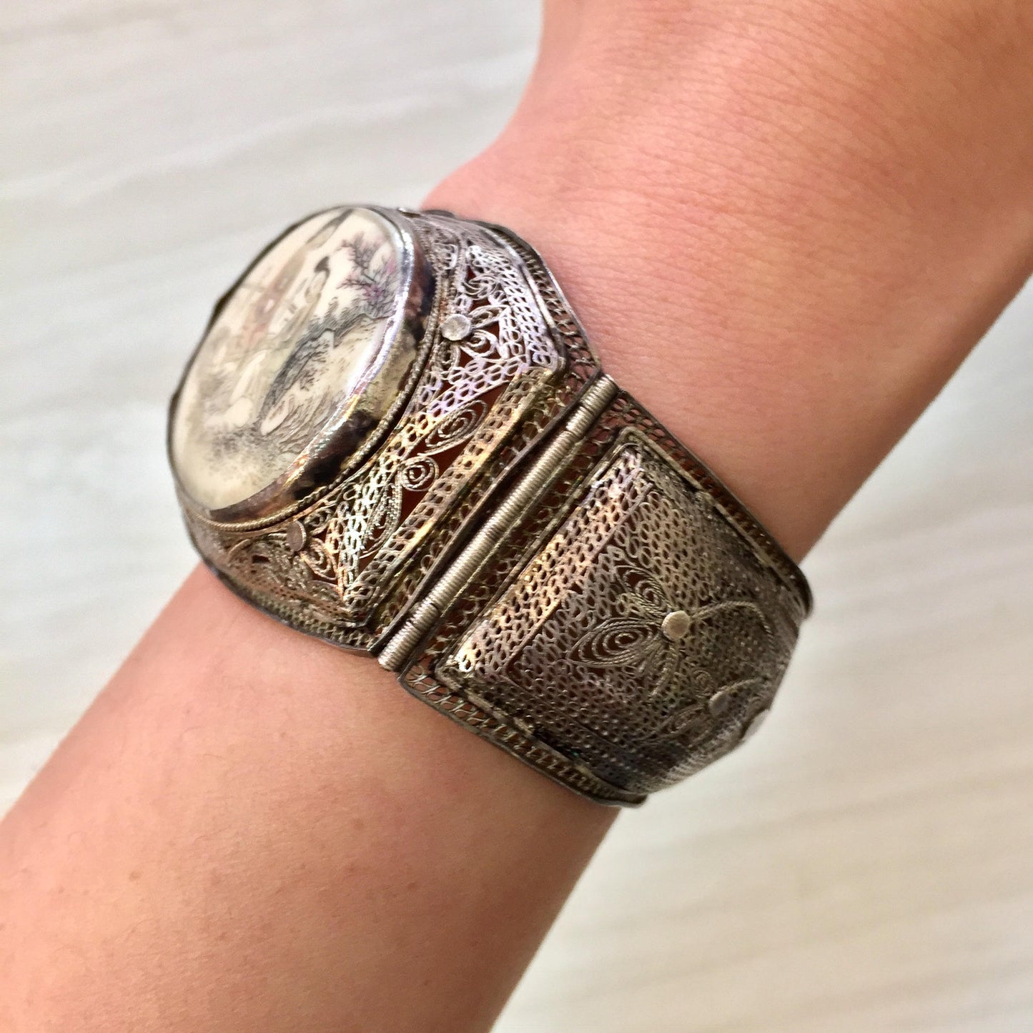 Antique sterling silver hinged bracelet with intricately carved horn or scrimshaw panels featuring Asian motifs, showcasing detailed filigree metalwork.