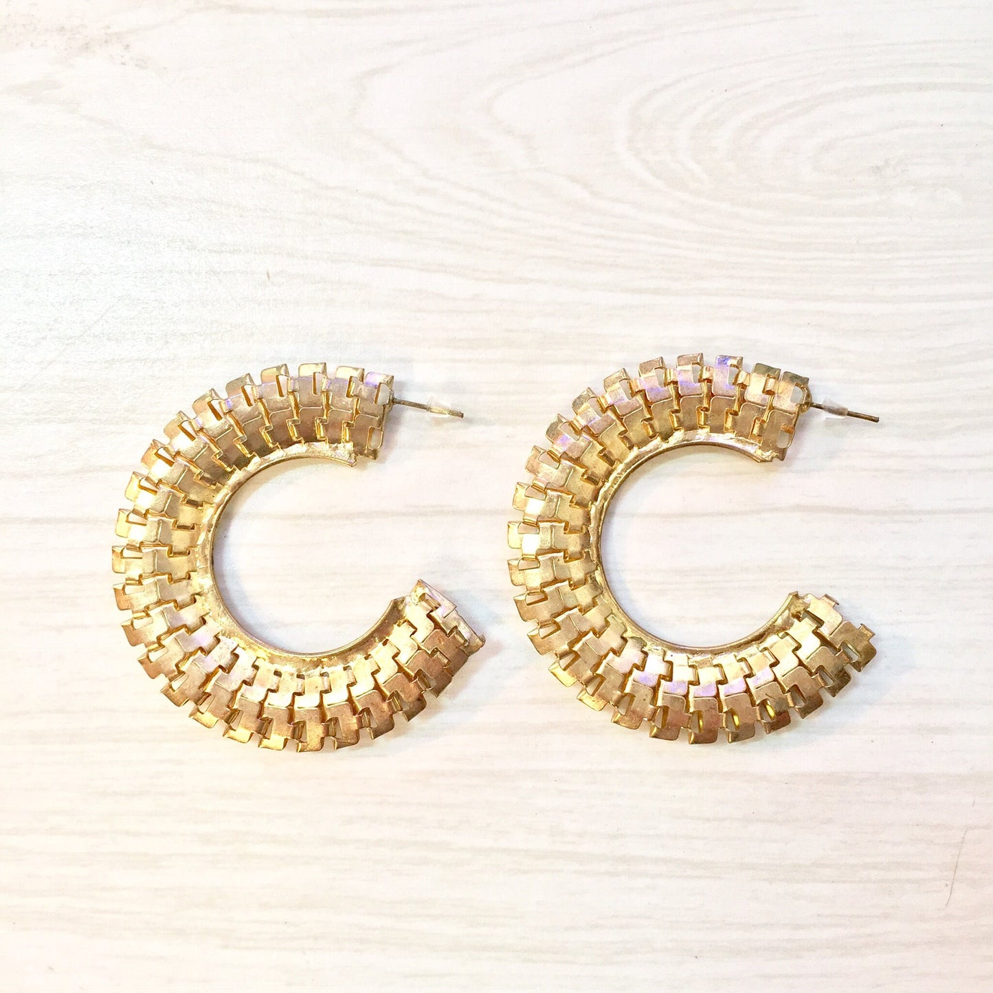 Vintage gold-toned hoop earrings with woven design, costume jewelry from the 80s or 90s era, statement piece and potential holiday gift idea.