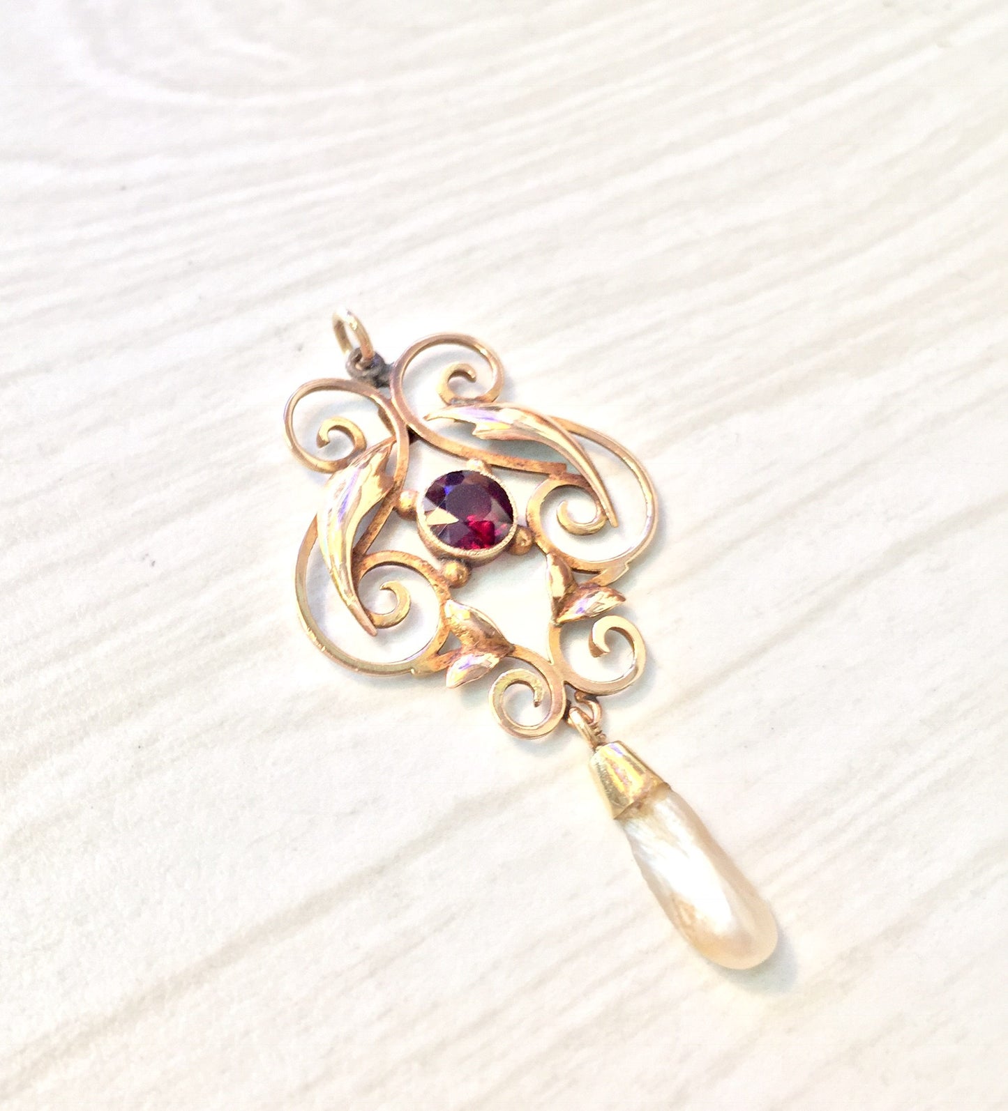 Antique 10K gold pendant featuring intricate swirl design with a dangling teardrop fresh water pearl and a purple amethyst gemstone accent.