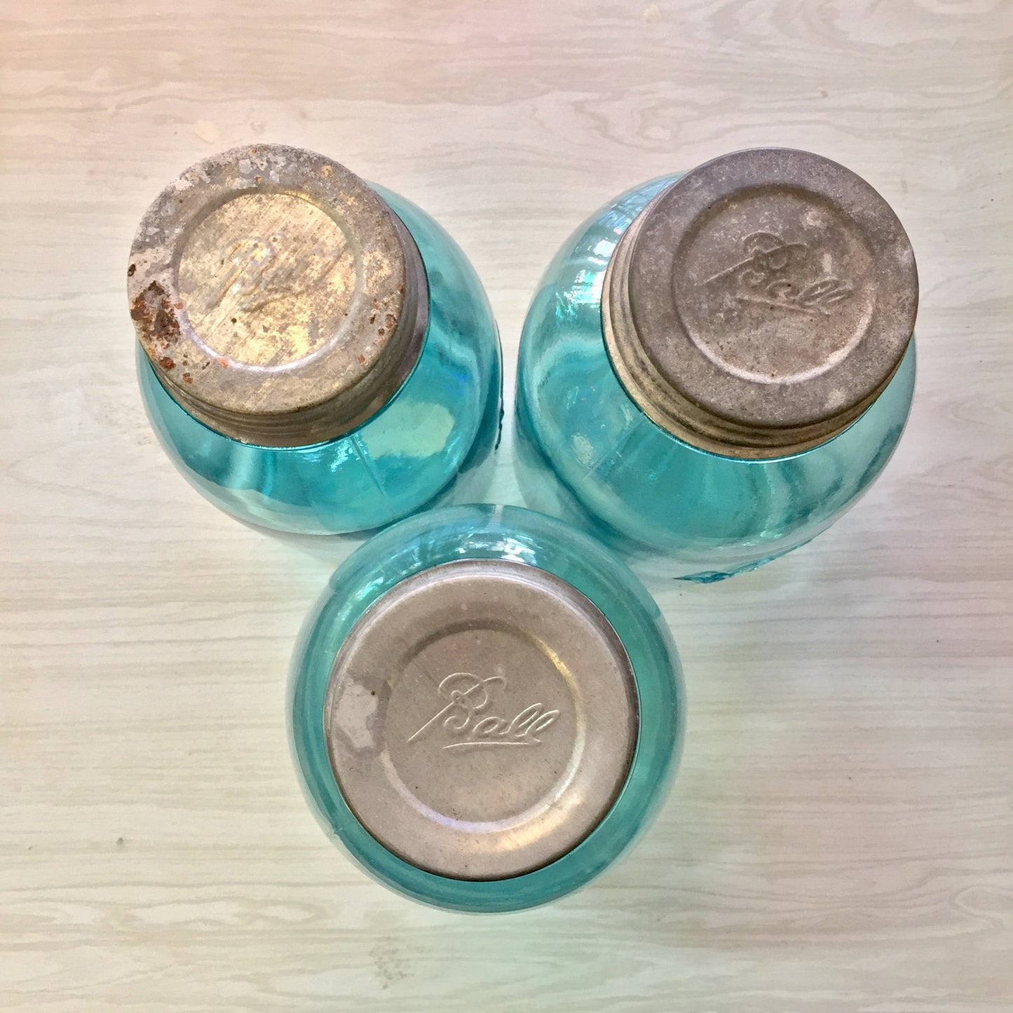 Set of three antique blue glass Ball Mason jars with zinc lids, hand blown canning jars for storage or decor.