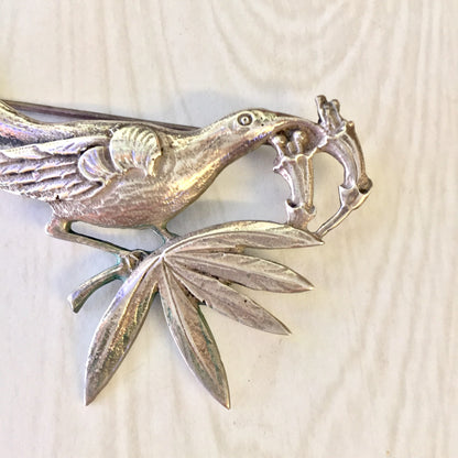 Vintage sterling silver bird brooch designed by Guglielmo Cini for Gump's, featuring a detailed bird perched on a branch with leaves, crafted in a realistic style showcasing Cini's artistry in silver jewelry design.