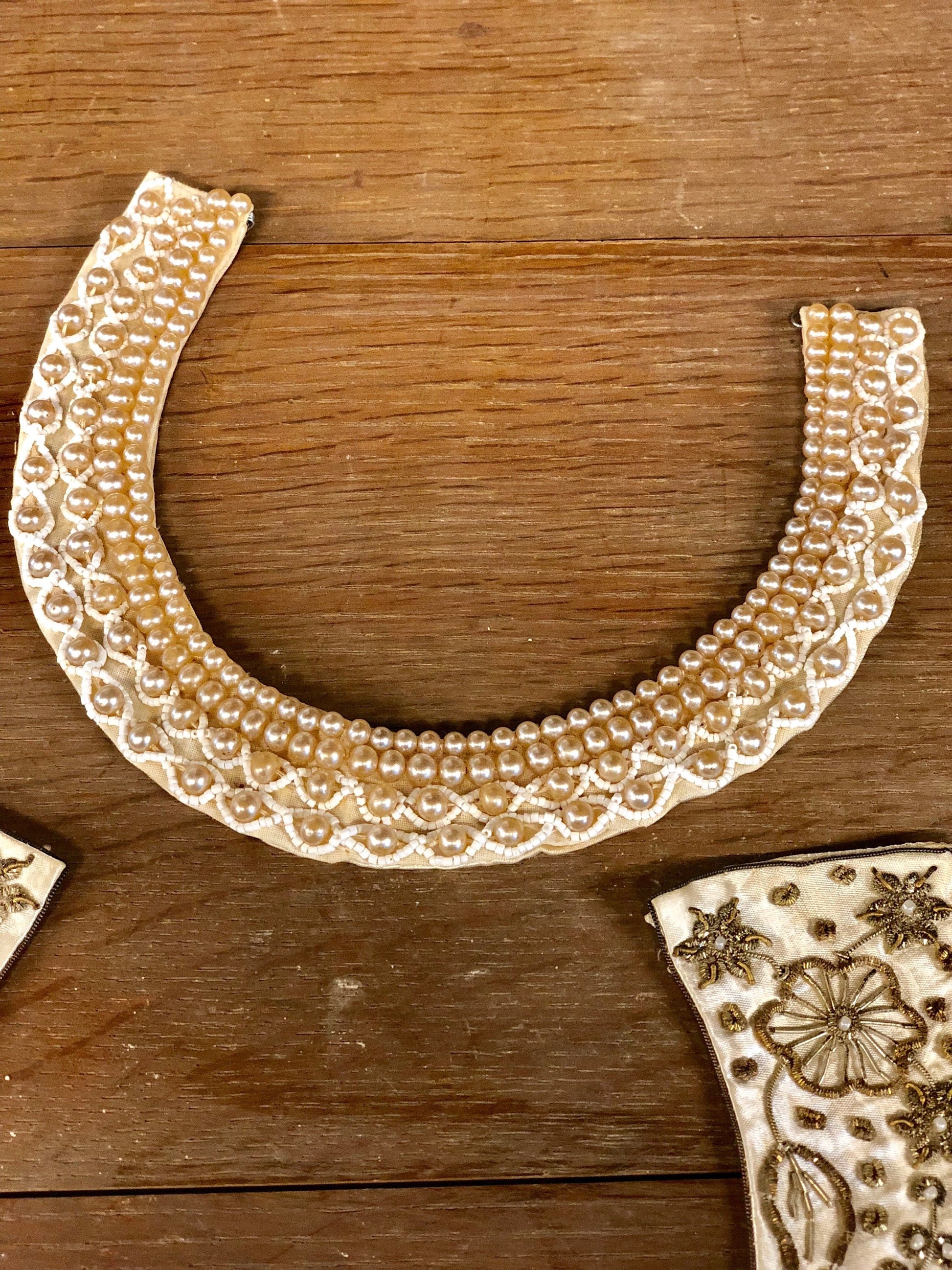 Vintage faux pearl beaded collar on wooden surface