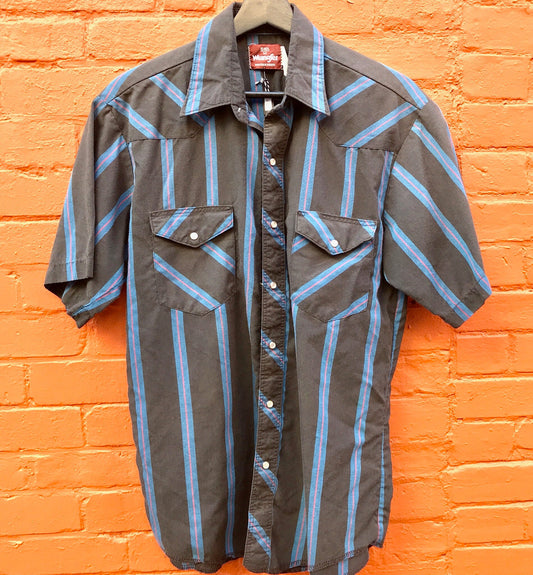 Vintage Wrangler striped western shirt with short sleeves and snap buttons hung on brick wall