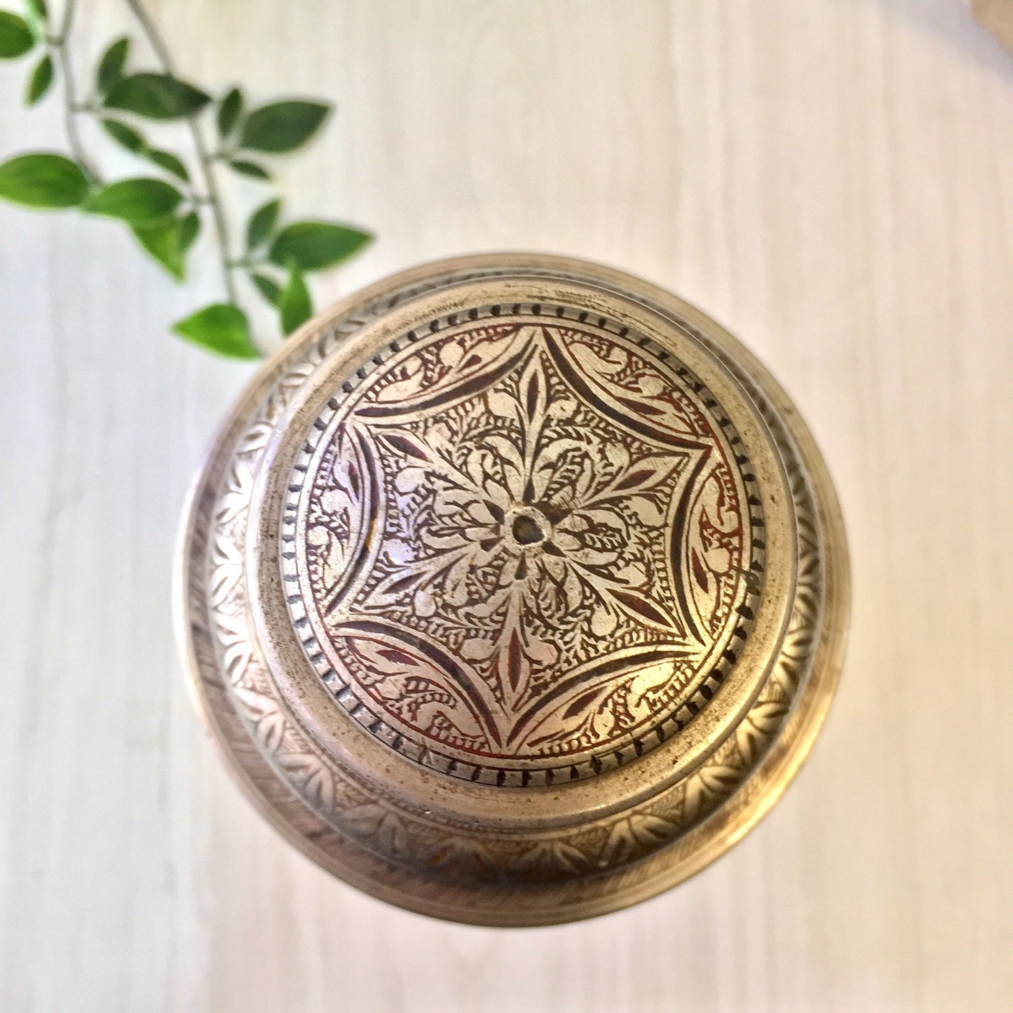 Vintage etched metal cocktail shaker with intricate floral design in silver and red, Indian-inspired mixology barware