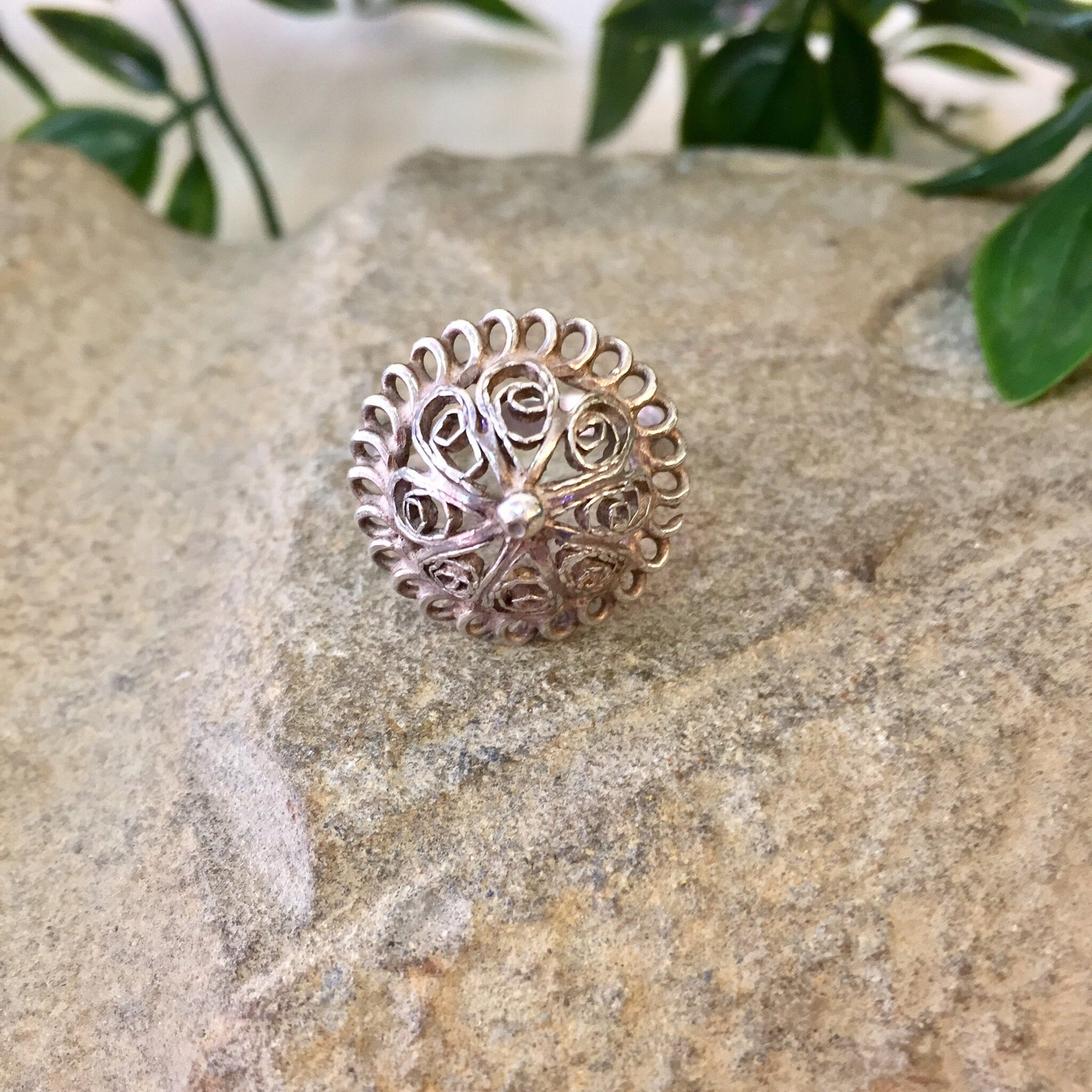 Vintage sterling silver dome ring with intricate cut-out design, placed on natural stone surface surrounded by greenery, perfect for weddings, gifts, or Mother's Day.