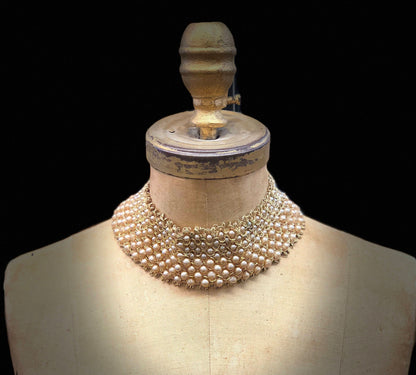 Vintage pearl and bead encrusted collar displayed on a mannequin, showcasing intricate beadwork and design reminiscent of classic fashion eras.