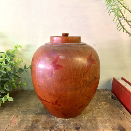 Vintage wooden jar with carved bird design in reddish-brown finish, used as decorative lidded container or urn