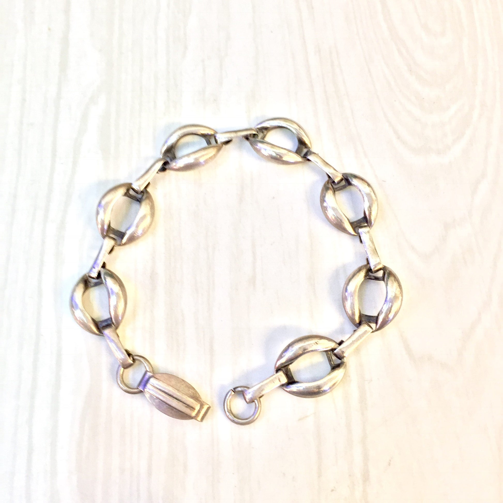 Vintage sterling silver link bracelet on light wooden background, simple jewelry gift idea for Valentine's Day or any occasion