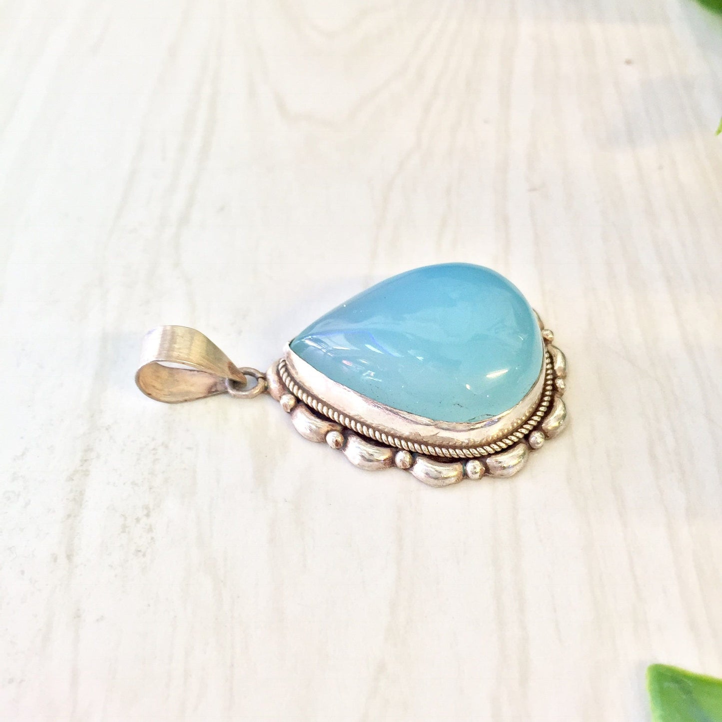 Vintage sterling silver pendant with a blue-green opalite stone, featuring intricate metalwork design.