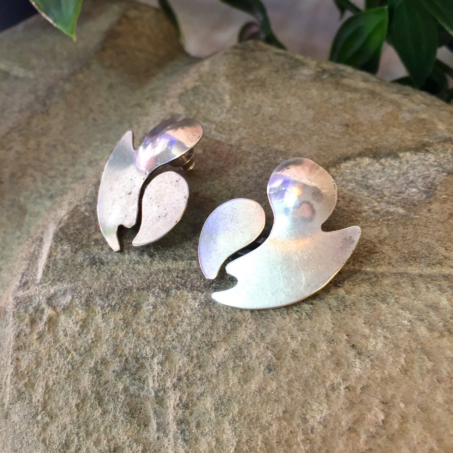 Vintage abstract silver earrings with iridescent finish on stone surface, perfect as a statement jewelry piece or Mother's Day gift.