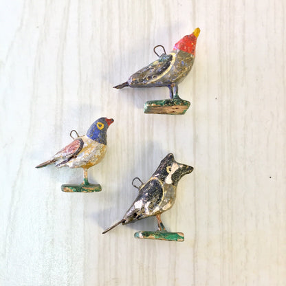 Colorful paper mache bird beads for jewelry making and crafts, featuring red, blue, yellow and brown birds on wire loops, suitable for necklaces or bracelets.