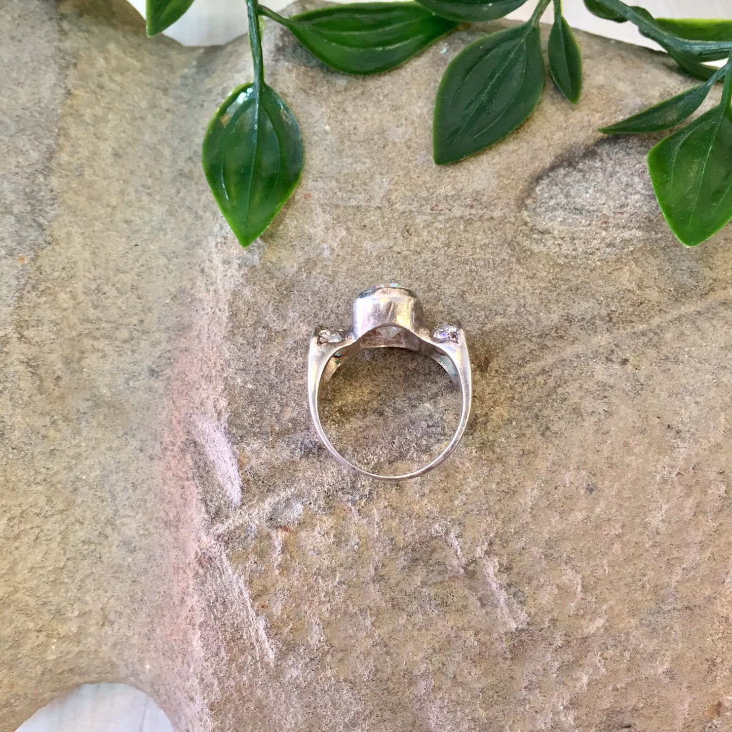 Vintage sterling silver statement ring with leaf design on stone background surrounded by greenery, suitable for engagement, wedding or cocktail jewelry